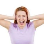 A woman in distress covering her ears, illustrating overwhelming stress related to plumbing decisions for a garbage disposal.