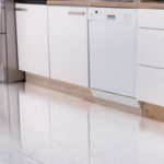 Modern kitchen with sleek cabinetry, dishwasher, and stainless steel appliances, highlighting plumbing concerns.