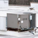 Rooftop HVAC unit on flat roof, gray exterior and ducts, vital for climate control at B & D Plumbing, Heating & A/C.