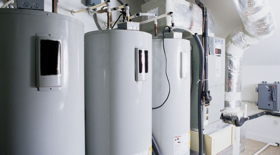 Three metallic gray water heaters with pipe systems and ventilation ducts, part of B & D Plumbing’s infrastructure.
