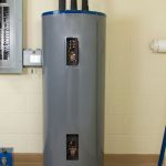 Water heater with cylindrical shape, blue accents, and control panel; B & D Plumbing emphasizes maintenance education.