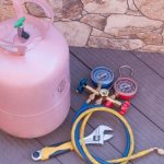 Refrigerant tank with gauges and hoses, essential tools for HVAC maintenance and air conditioning services.