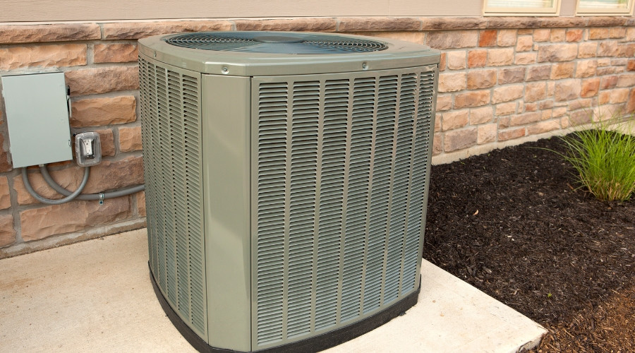 Air conditioning unit installed outside a building, relevant to HVAC services and efficiency discussions.