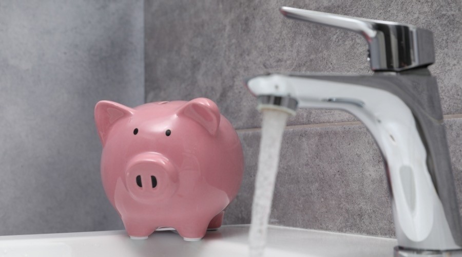 Water flowing from faucet and filling pink piggy bank, illustrating water-saving practices.