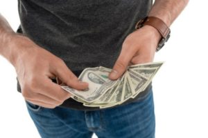 Person counting cash, emphasizing potential savings from switching to natural gas boilers and energy-efficient heating systems.