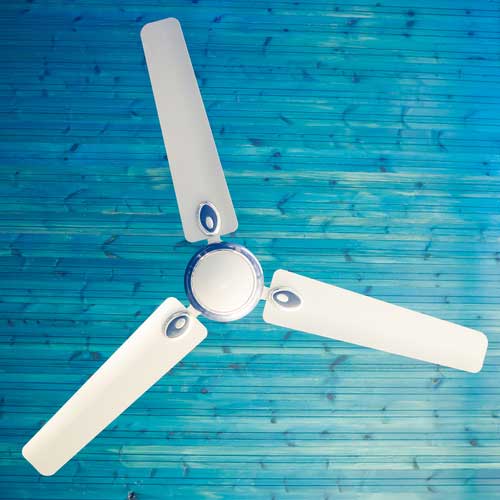 Ceiling fan with three white blades against a blue background, representing home cooling solutions for summer heat.